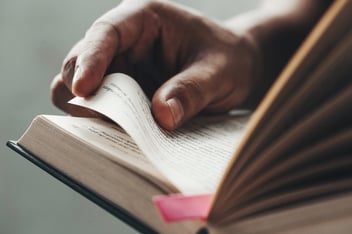 Close up man hands young man opening and reading a book